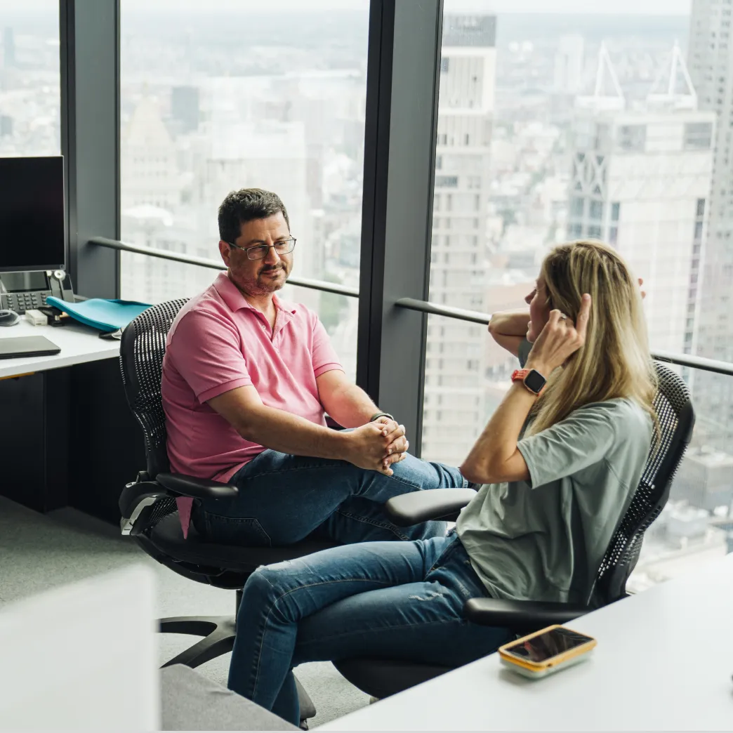 Two IEX coworkers chat in the corporate office lounge.