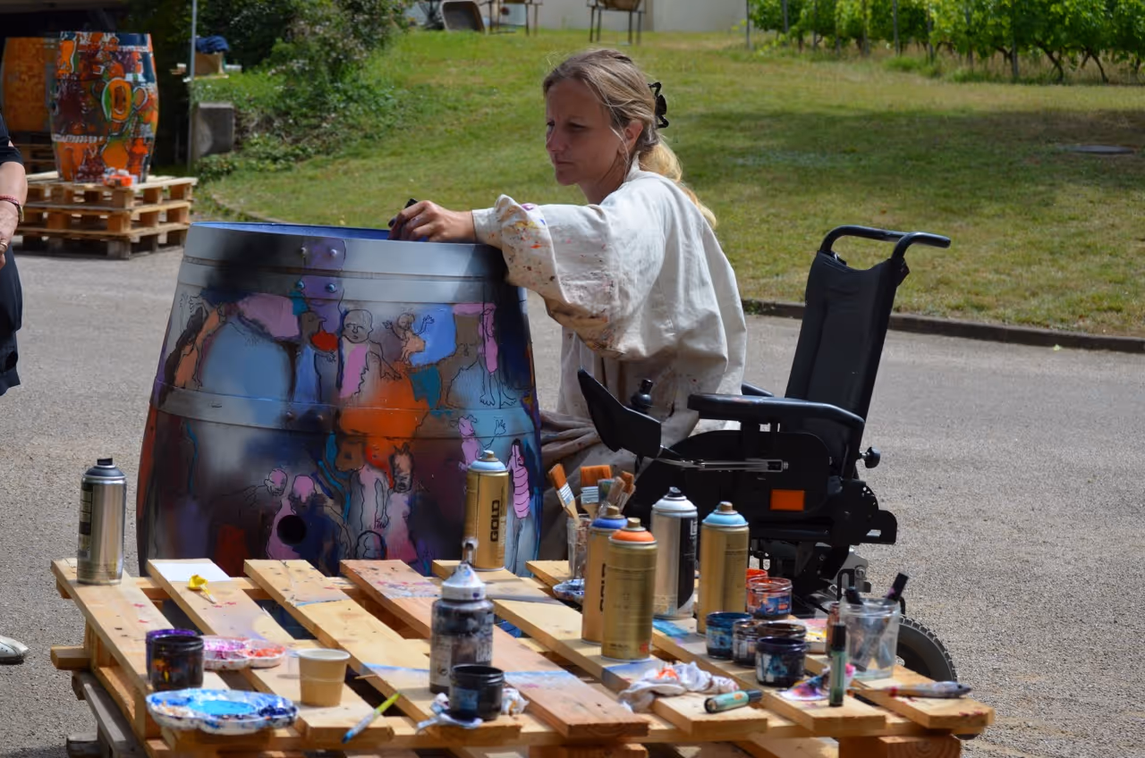 Cours de peinture en plein air avec des participants dont une personne en fauteuil roulant, atelier artistique inclusif