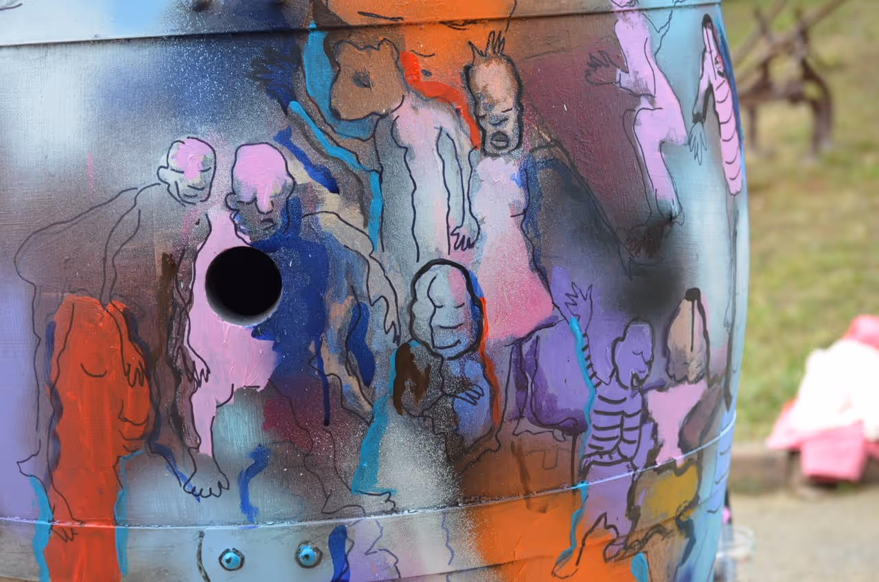 Participants d'un atelier de peinture créative en extérieur avec une grande œuvre colorée