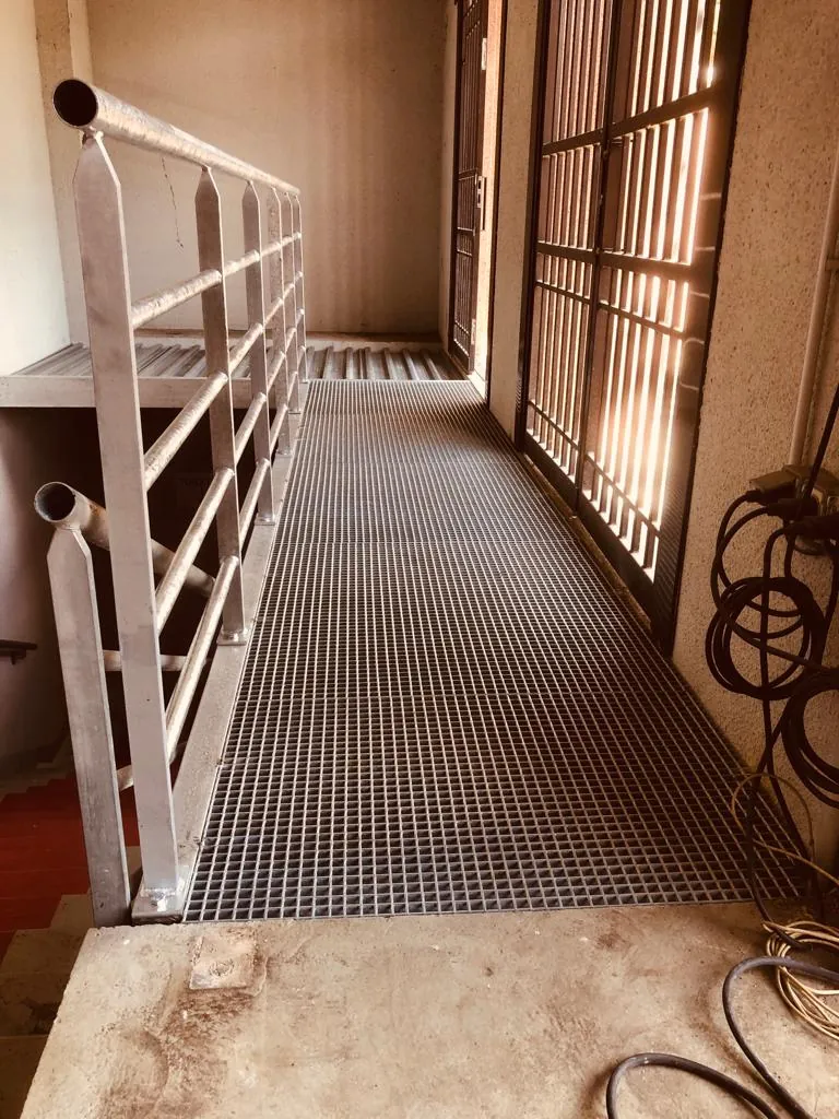 Détail de jonction entre la passerelle métallique et le mur porteur, ancrage par platines boulonnées