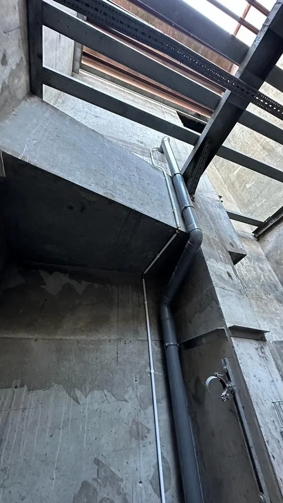 Cage technique en béton avec colonne d'évacuation et structure métallique en partie haute, travaux tous corps d'état