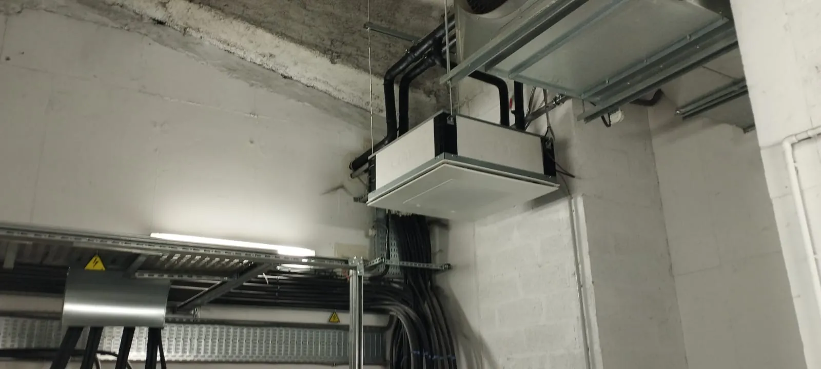 Unité de climatisation cassette encastrée au plafond avec réseau de gaines isolées noires