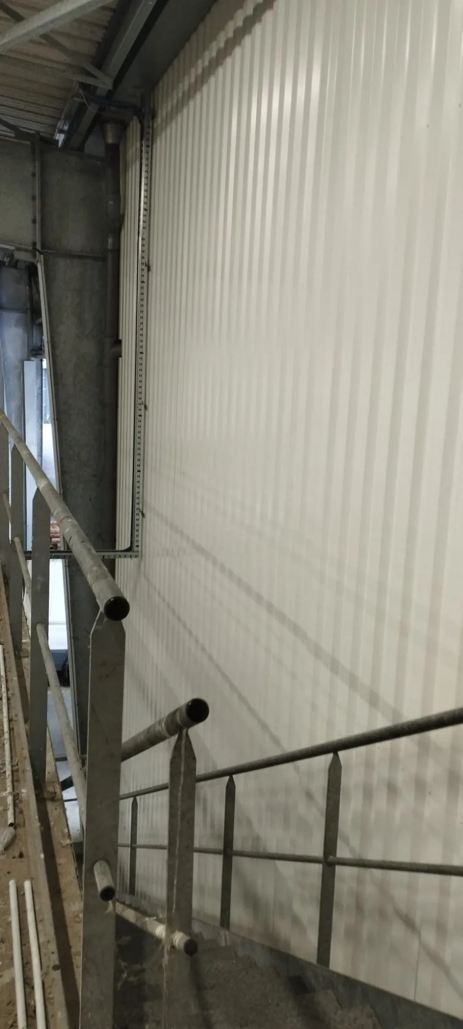 Bardage intérieur blanc nervuré avec garde-corps métallique - Vue en hauteur chantier industriel