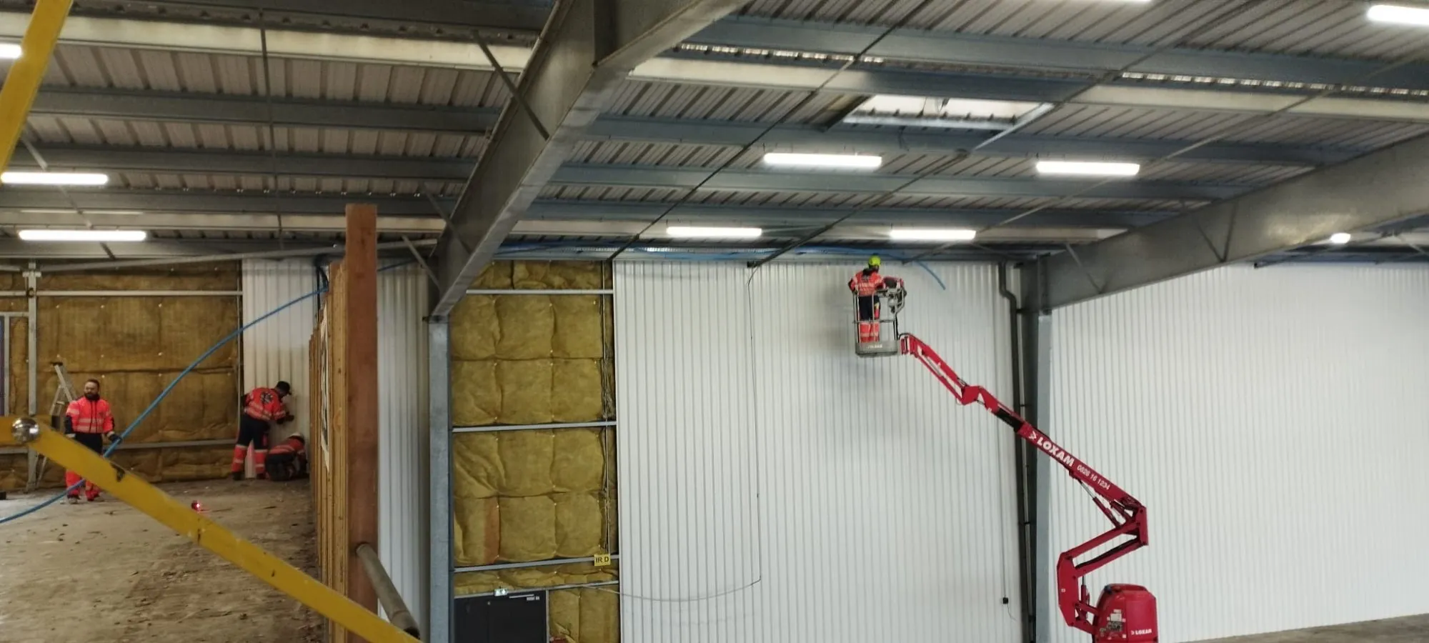 Isolation thermique hangar avec laine de roche - Travaux en hauteur sur nacelle élévatrice