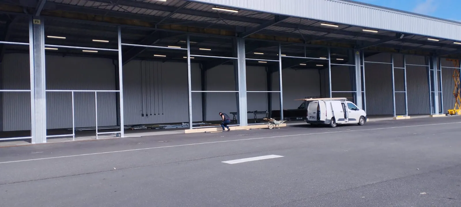 Façade d'un hangar industriel avec structure métallique en cours d'installation — chantier BTP