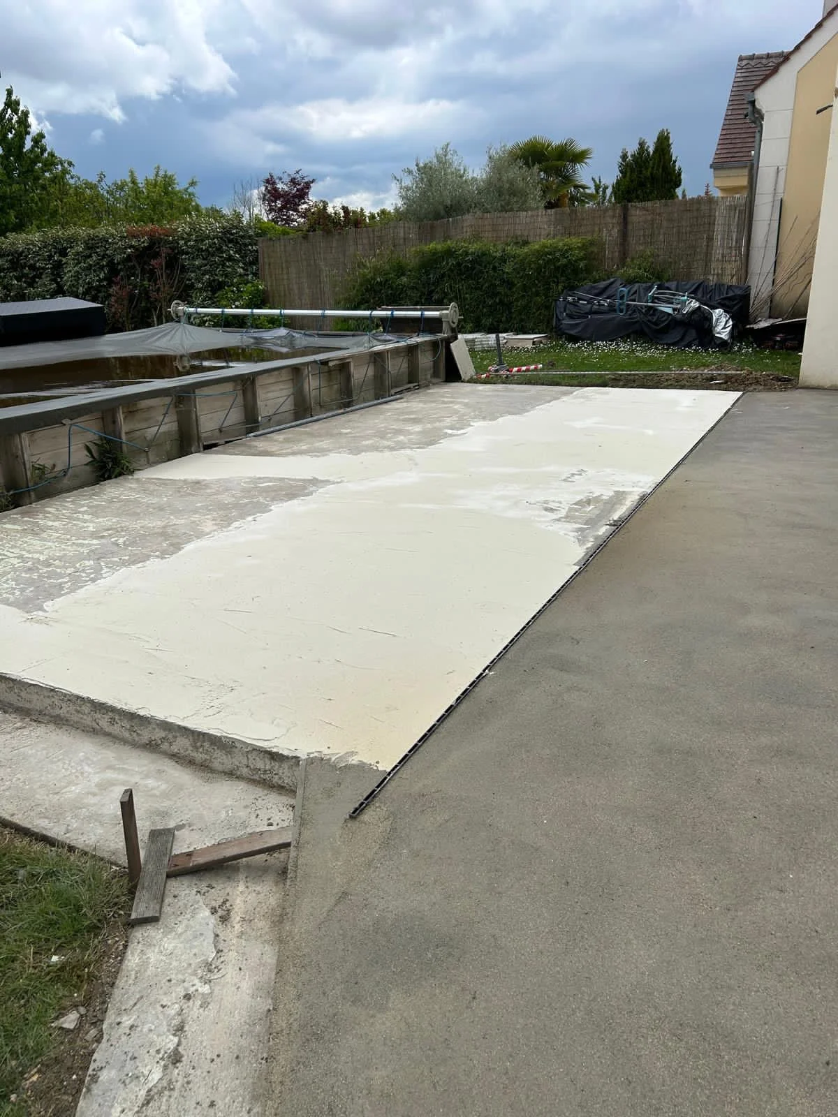 Vue de la dalle béton poncée et enduite d'une couche de ragréage, chantier terrasse piscine