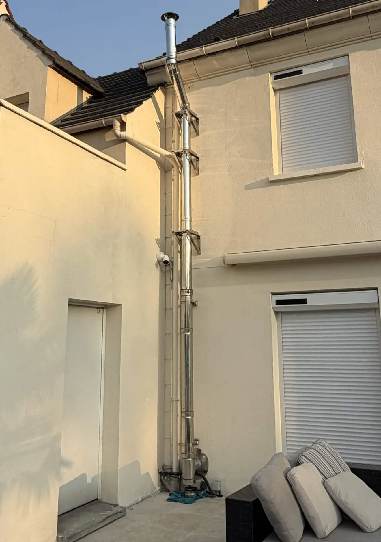 Conduit de ventilation inox neuf installé en façade d'immeuble — rénovation VMC extérieure réussie