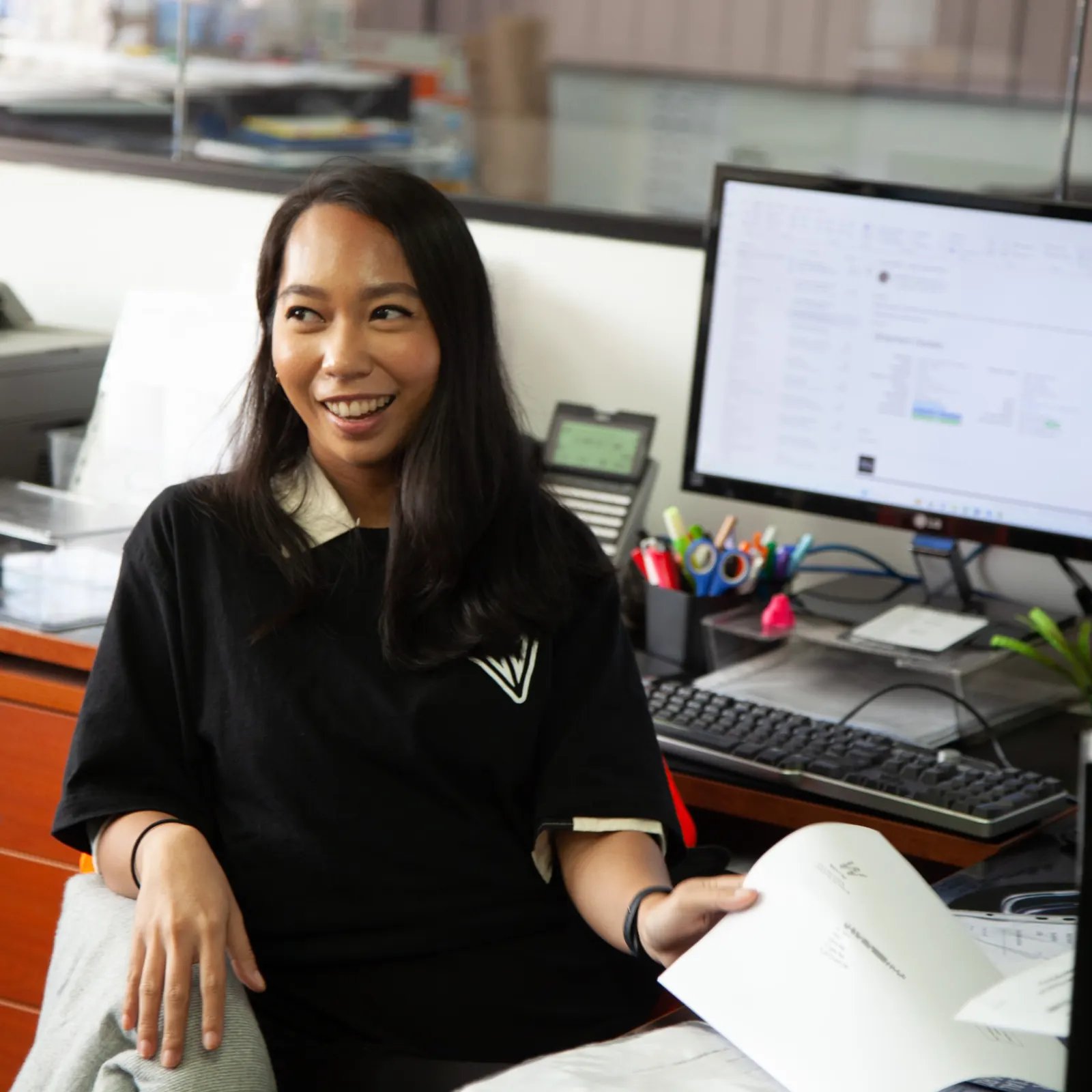 Fulfilment Australia team member reviewing a document at a desk in the warehouse office