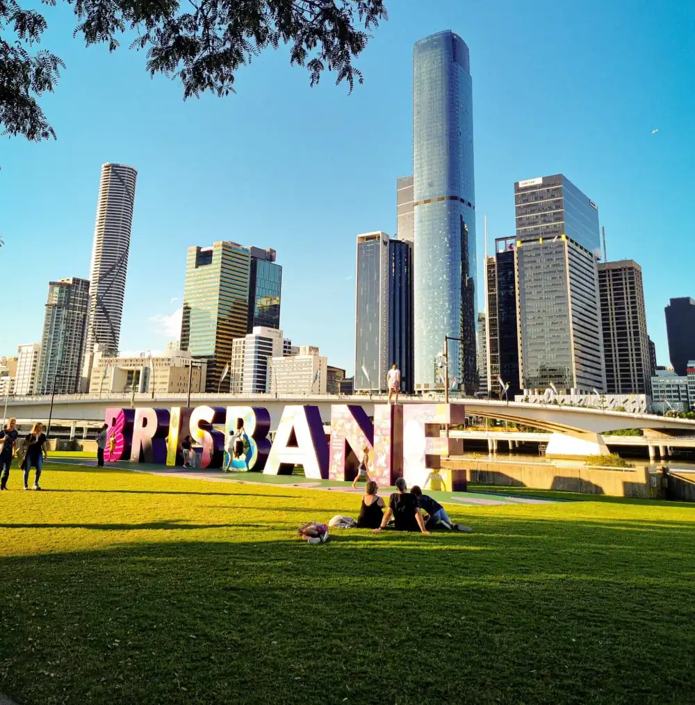 The Brisbane sign at South Bank with the city skyline behind