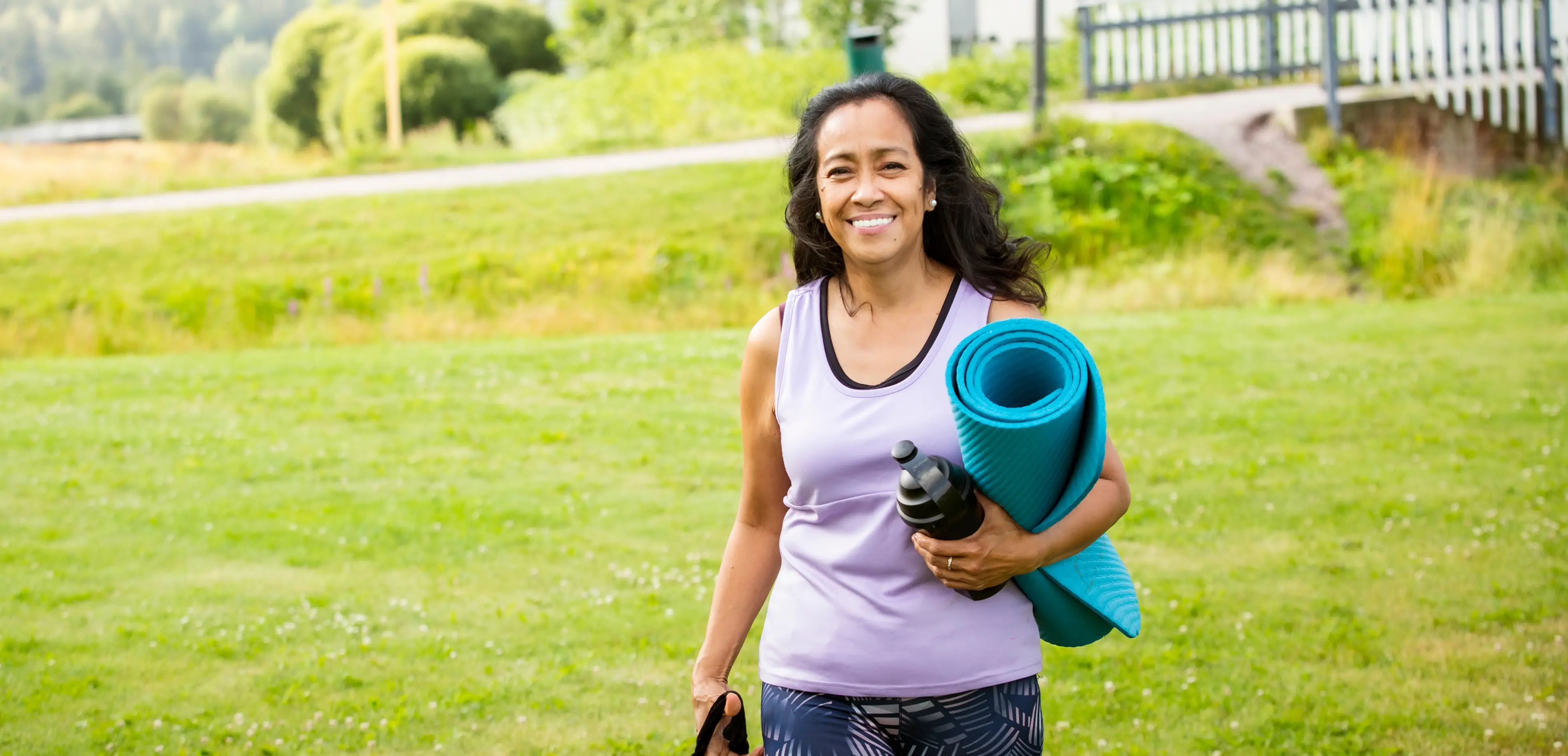 A woman walking with a yoga mat