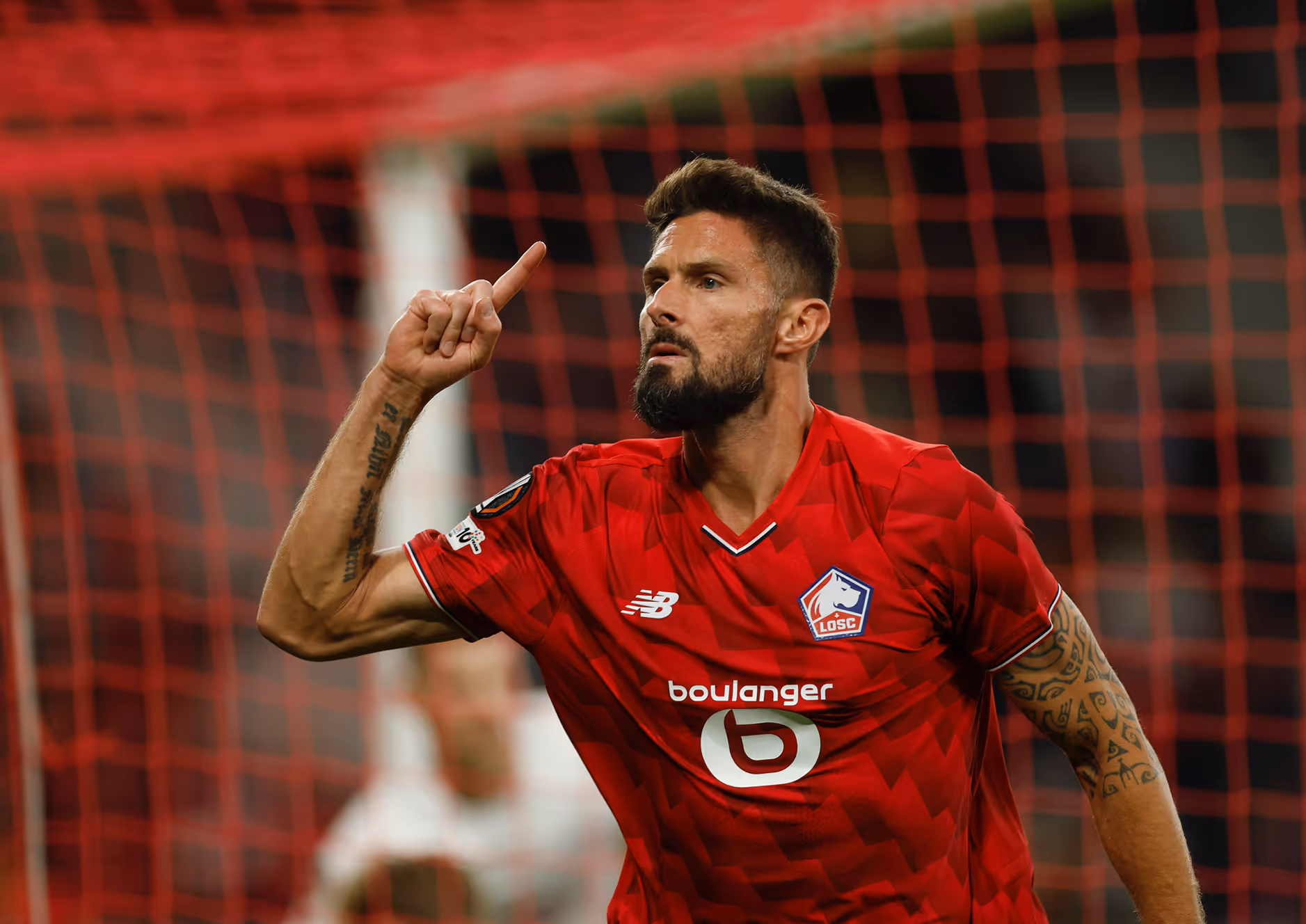 Groupe de personnes à la plage tirant un grand filet dans l'eau sous un ciel nuageux.