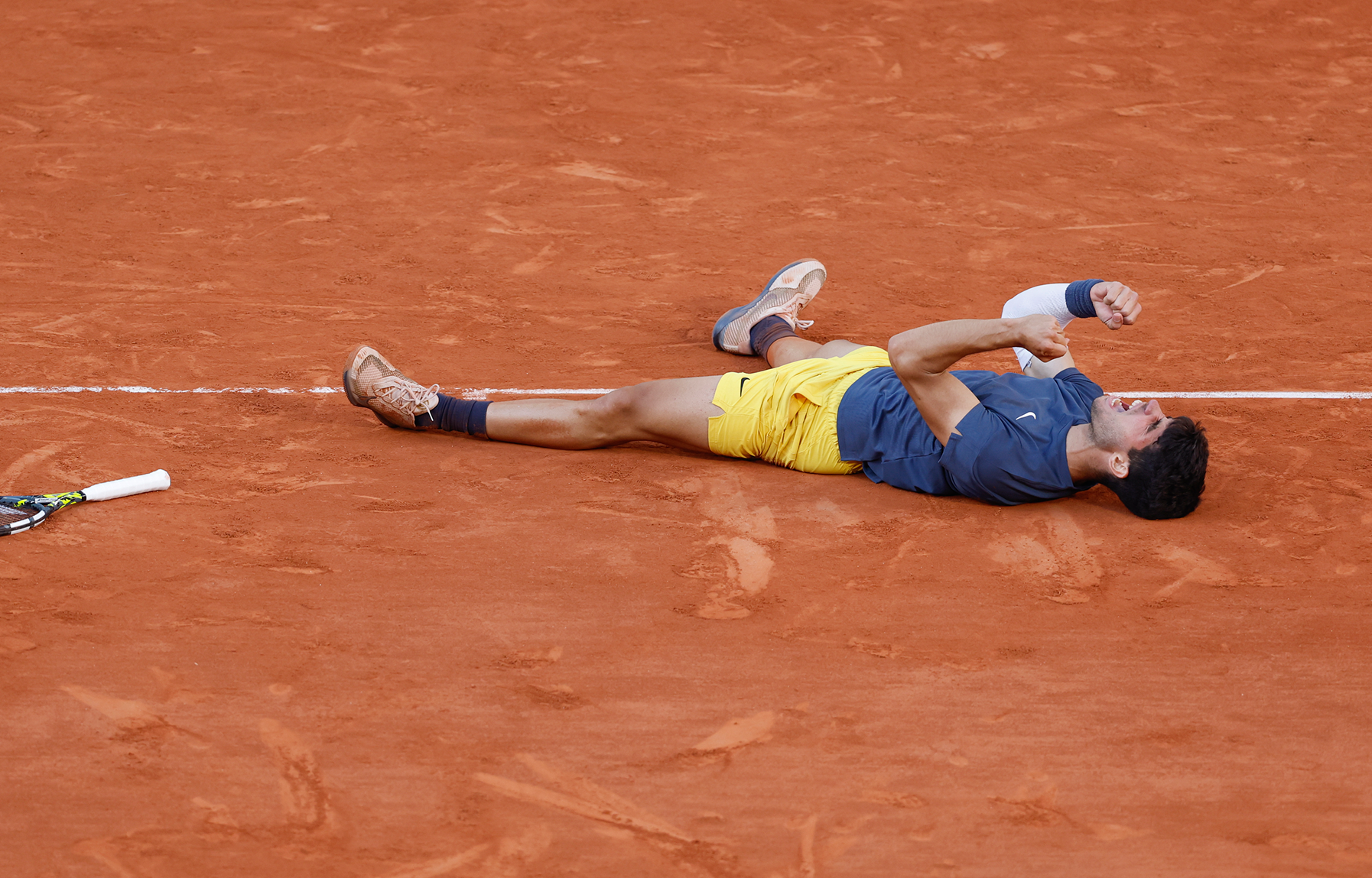 Homme regardant une grande planche inclinée produisant des étincelles lumineuses orange dans la nuit.