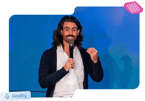 Speaker on stage holding a microphone during an MLOps reality talk