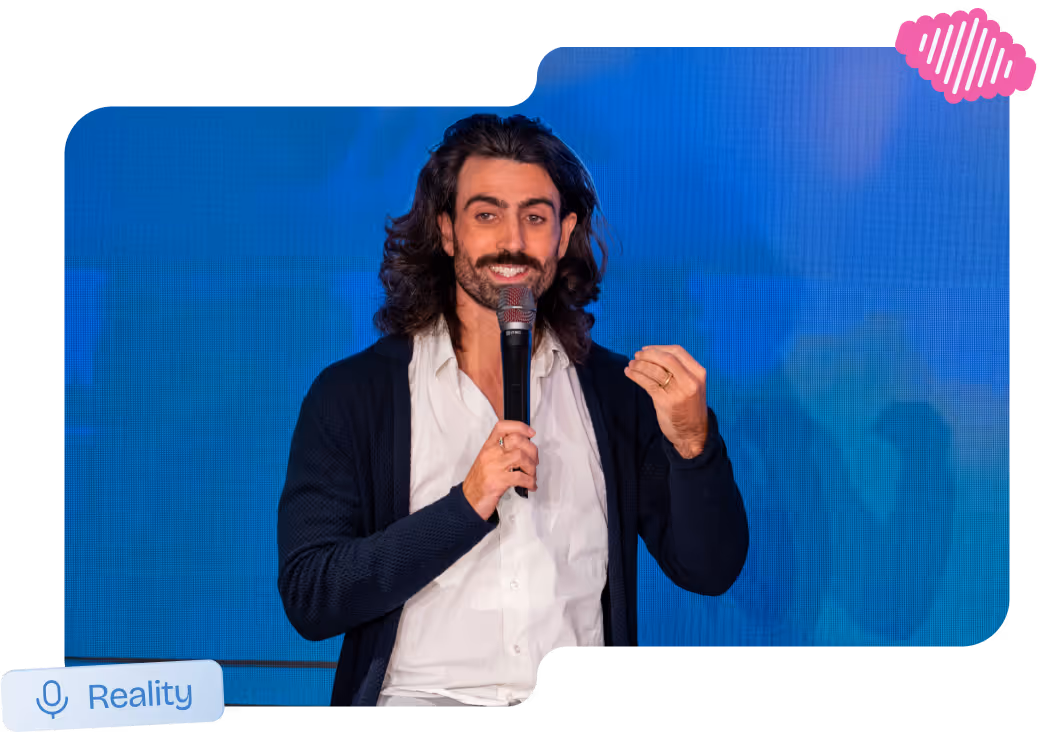 Speaker on stage holding a microphone during an MLOps reality talk