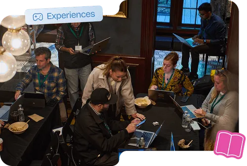 Participants collaborating on laptops during an immersive MLOps workshop experience