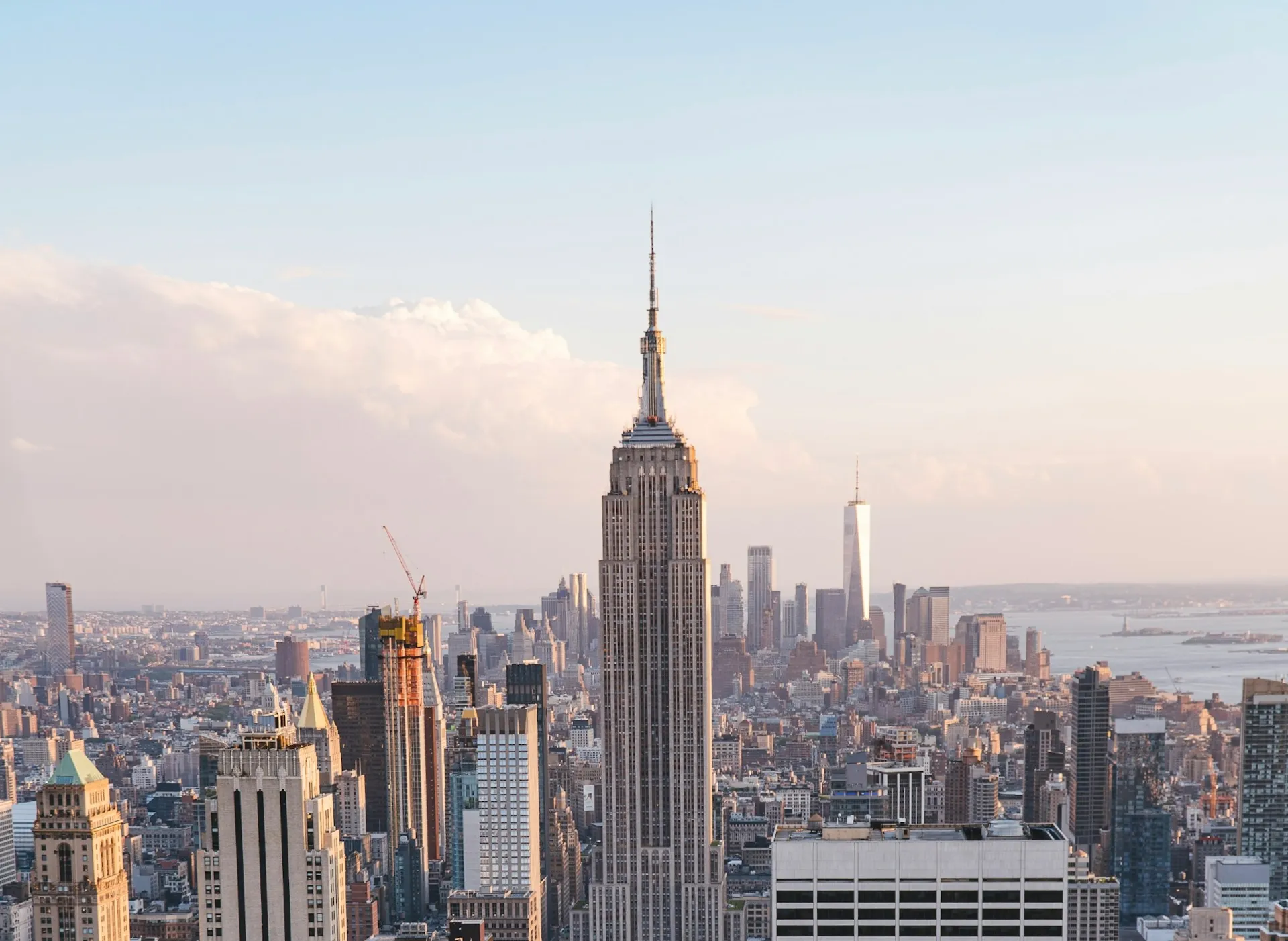 View of New York City skyline featuring the Empire State Building in the center during daylight.