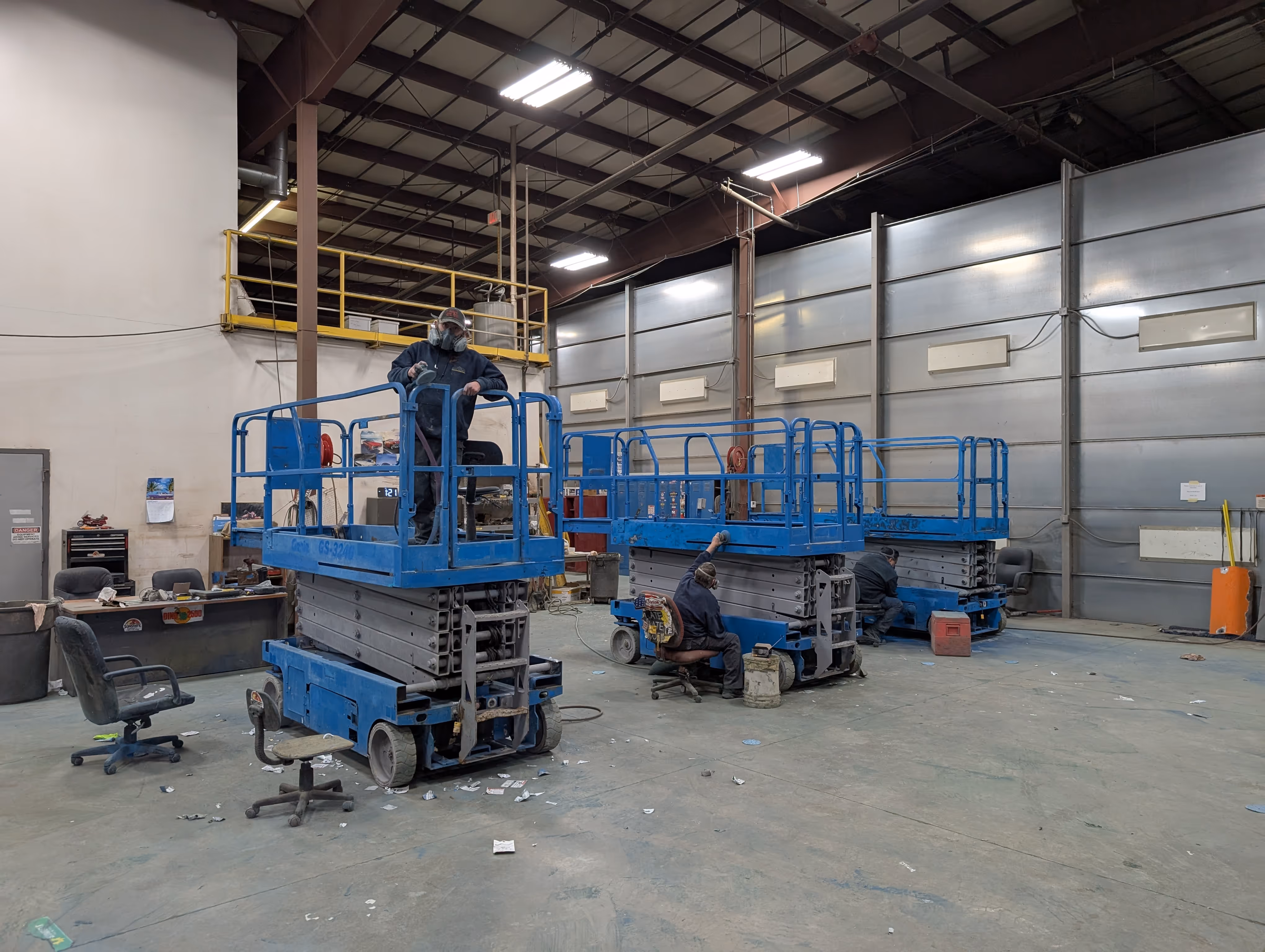 The team prepping a fleet of scissor lifts for paint