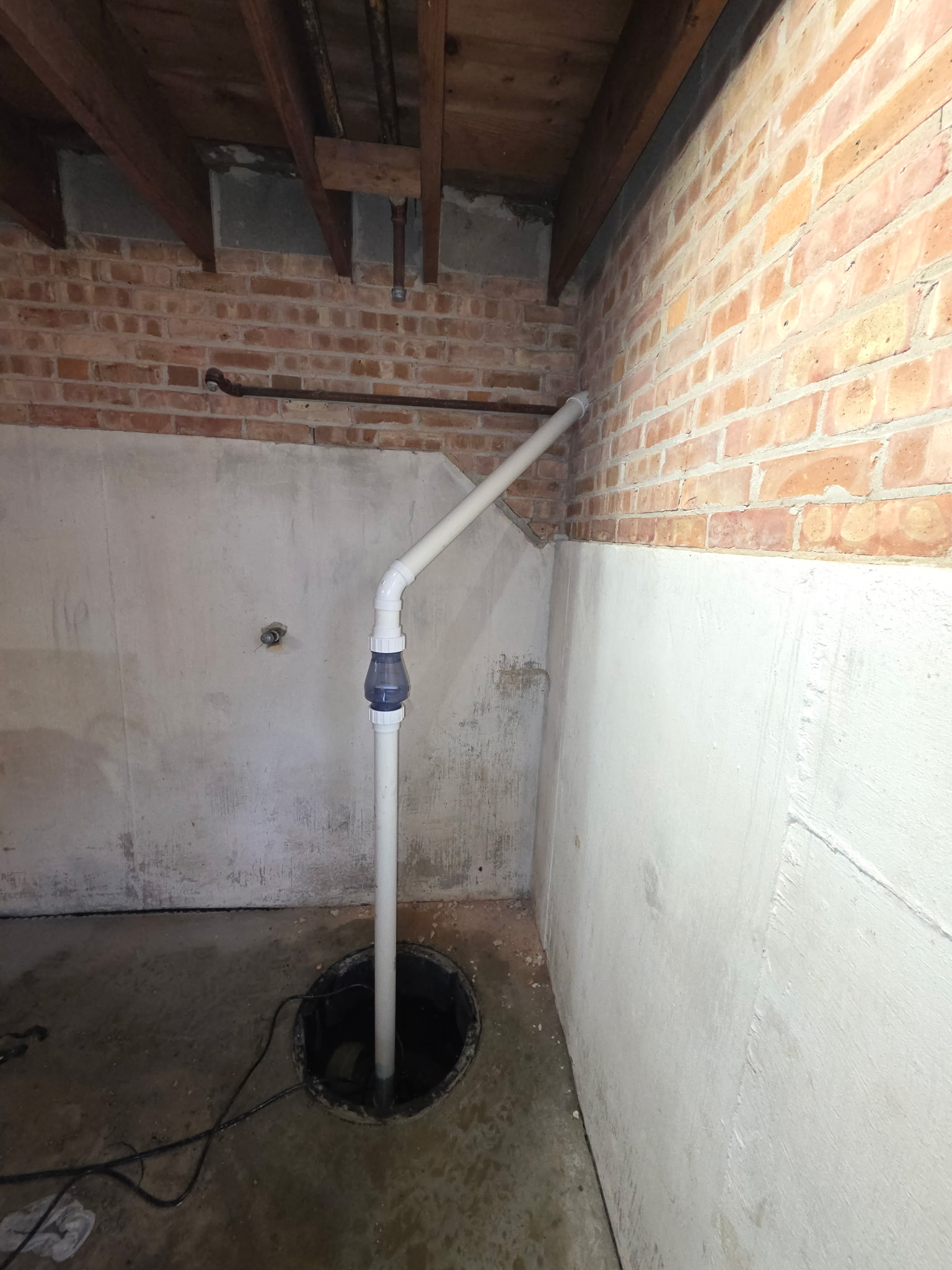 Sump pump discharge line and check valve in a Will County basement