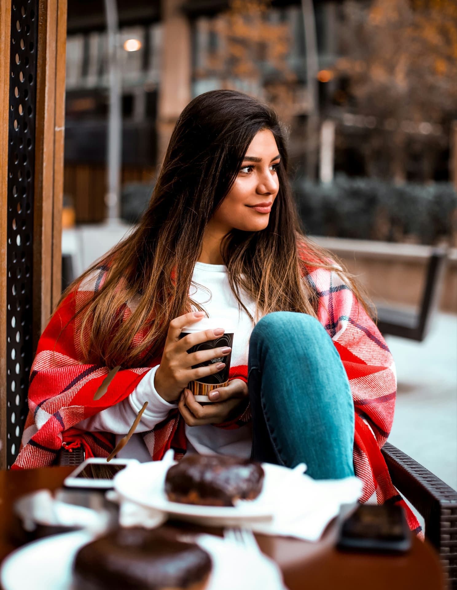 Une femme profite d’un café et d’un dessert en terrasse