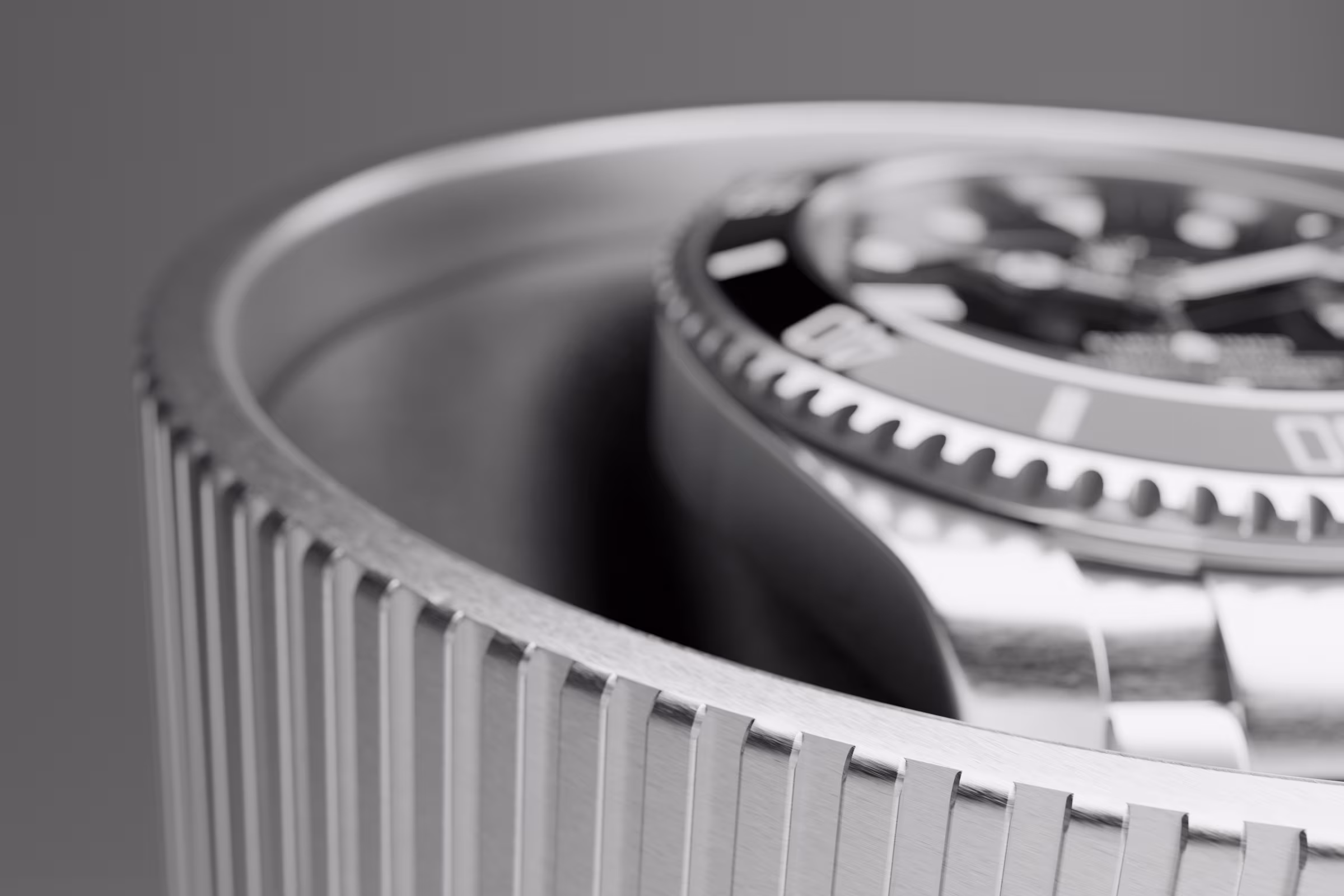 Close-up of a metallic watch bezel with serrated edges and part of the watch face in the background.