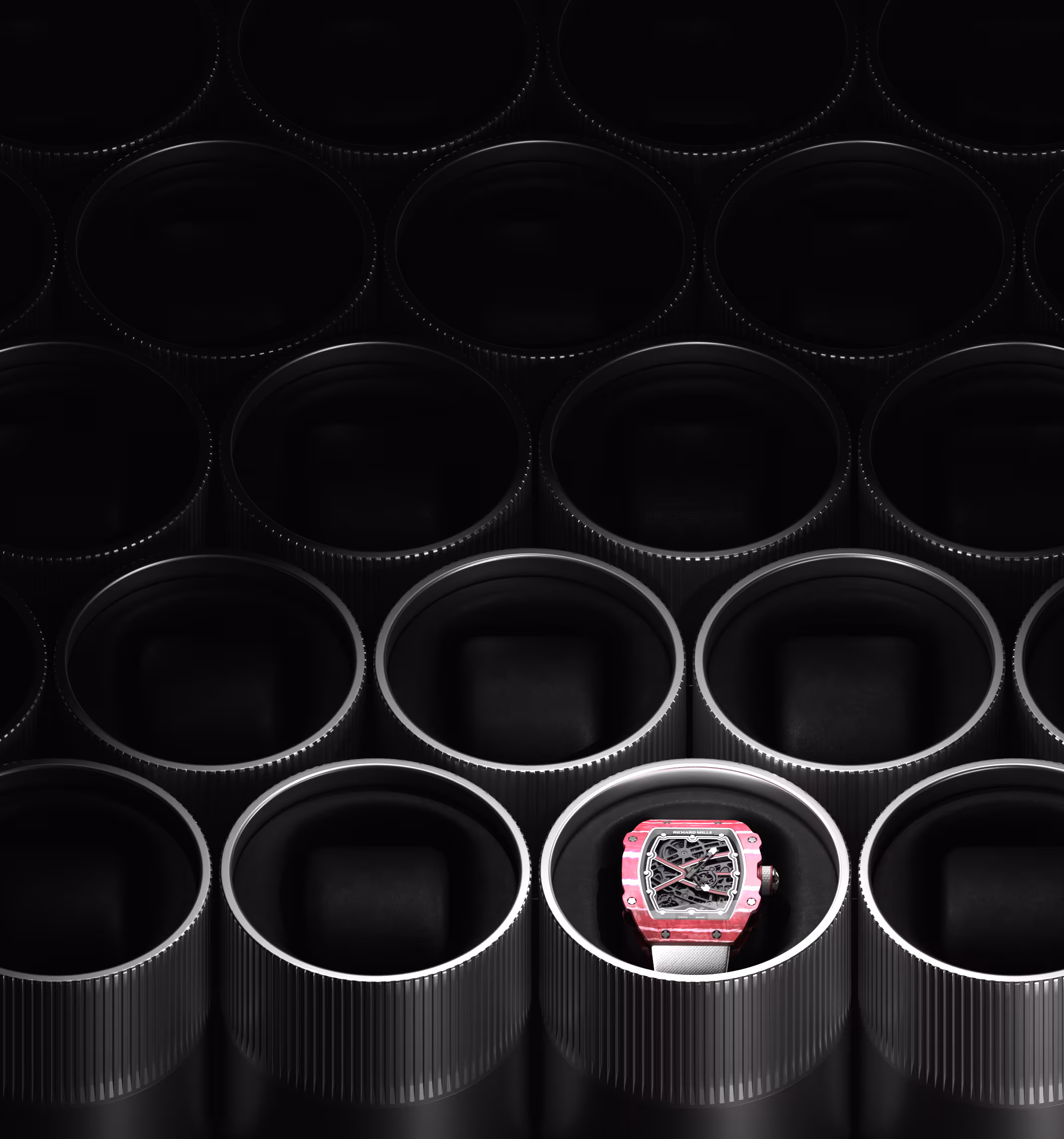 Pink and white wristwatch displayed inside a dark round container among identical empty containers.