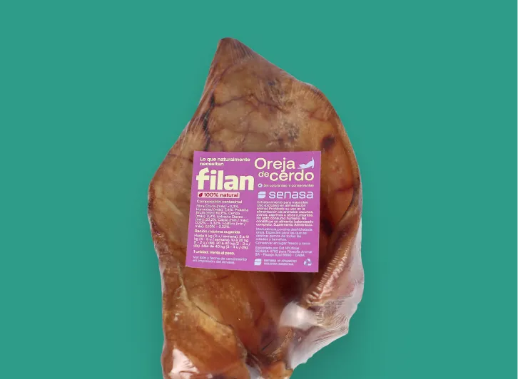 Oreja de cerdo natural empacada con etiqueta morada de la marca Filan sobre fondo verde.