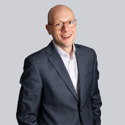 Mechanic in black gloves inspecting and repairing a car engine in a workshop.