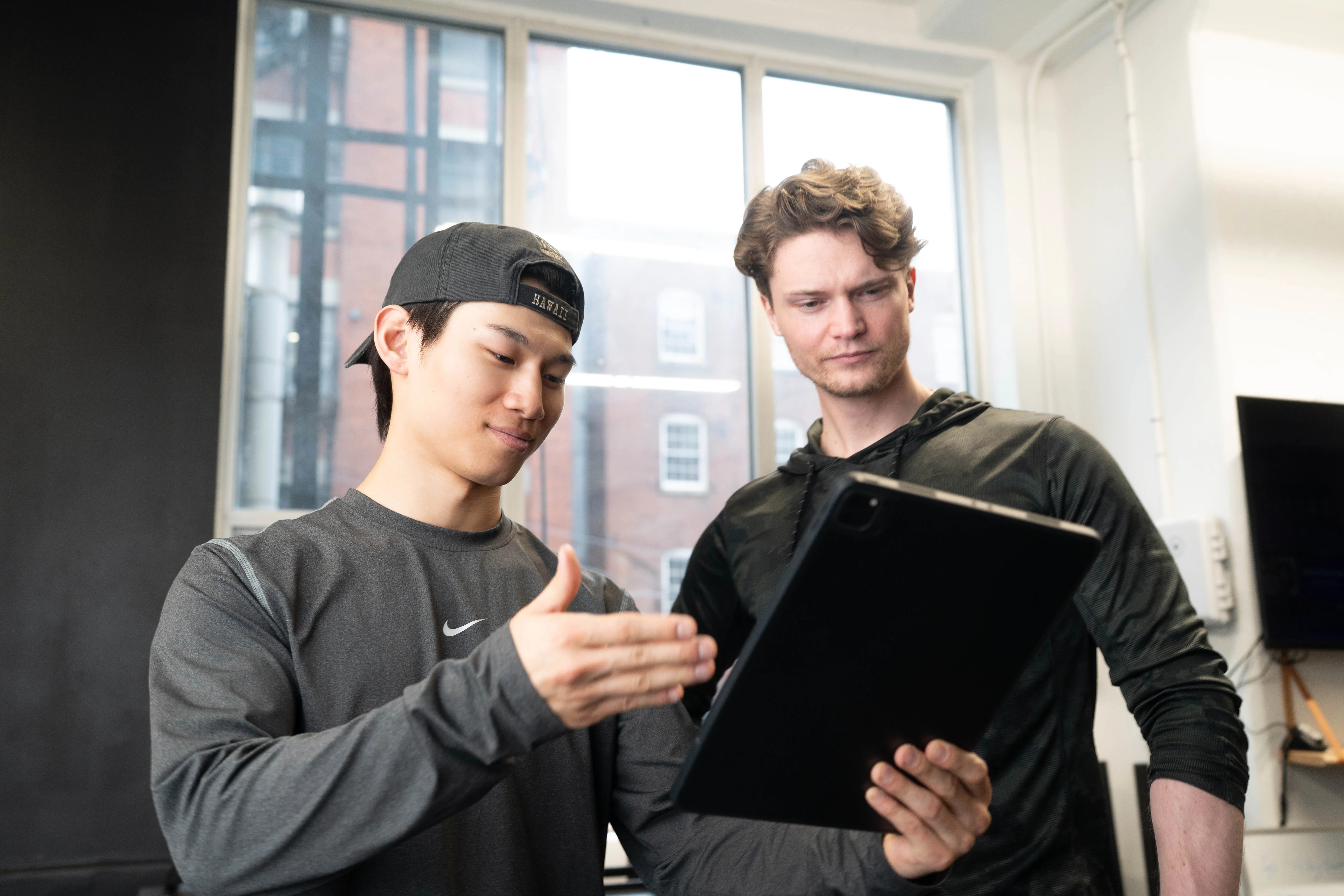 A personal trainer showing his tablet to his client.