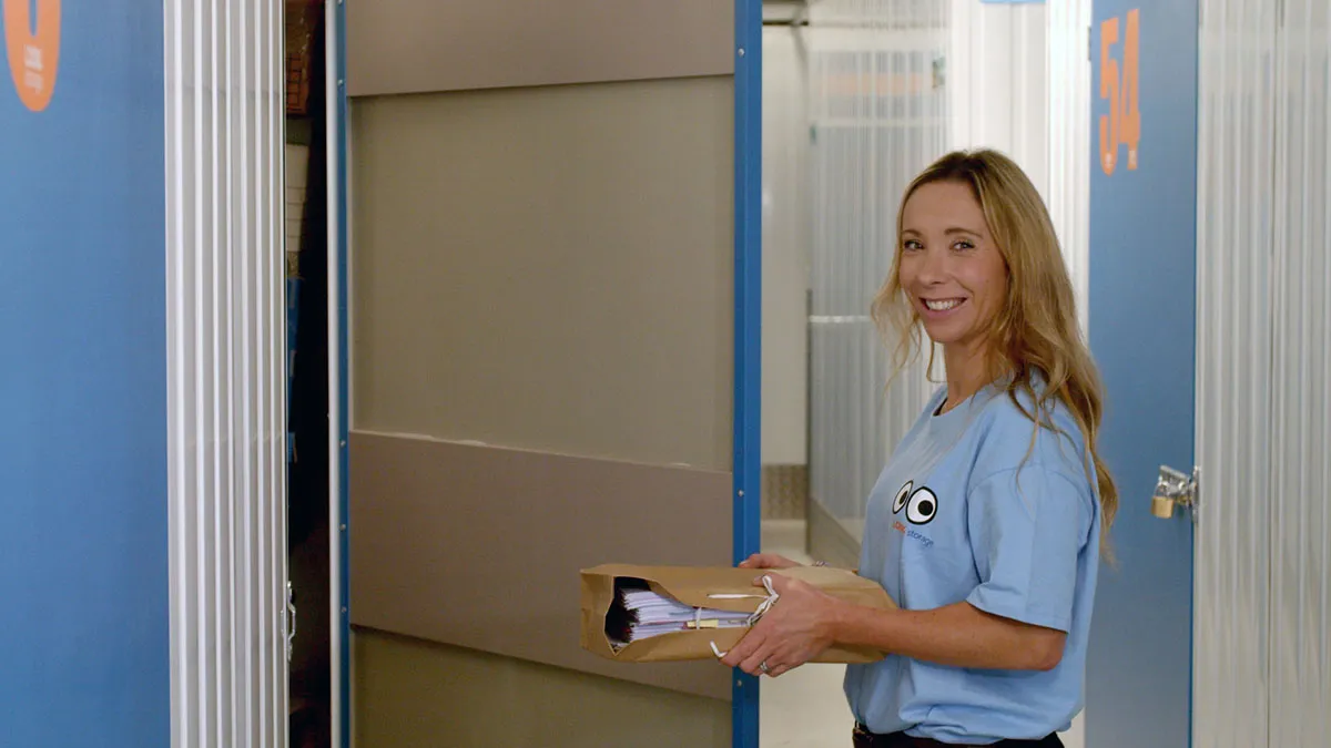 A LOOK self storage team member carrying items into a storage unit