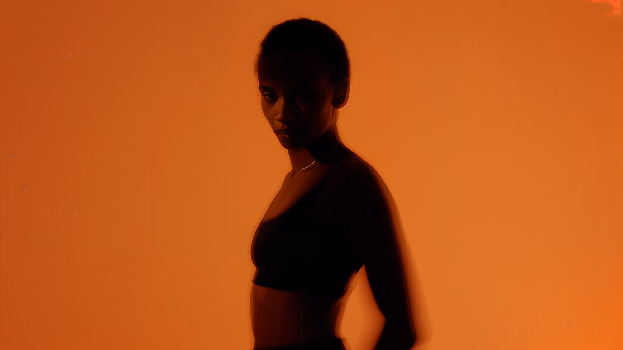 Woman on a blurred orange background.