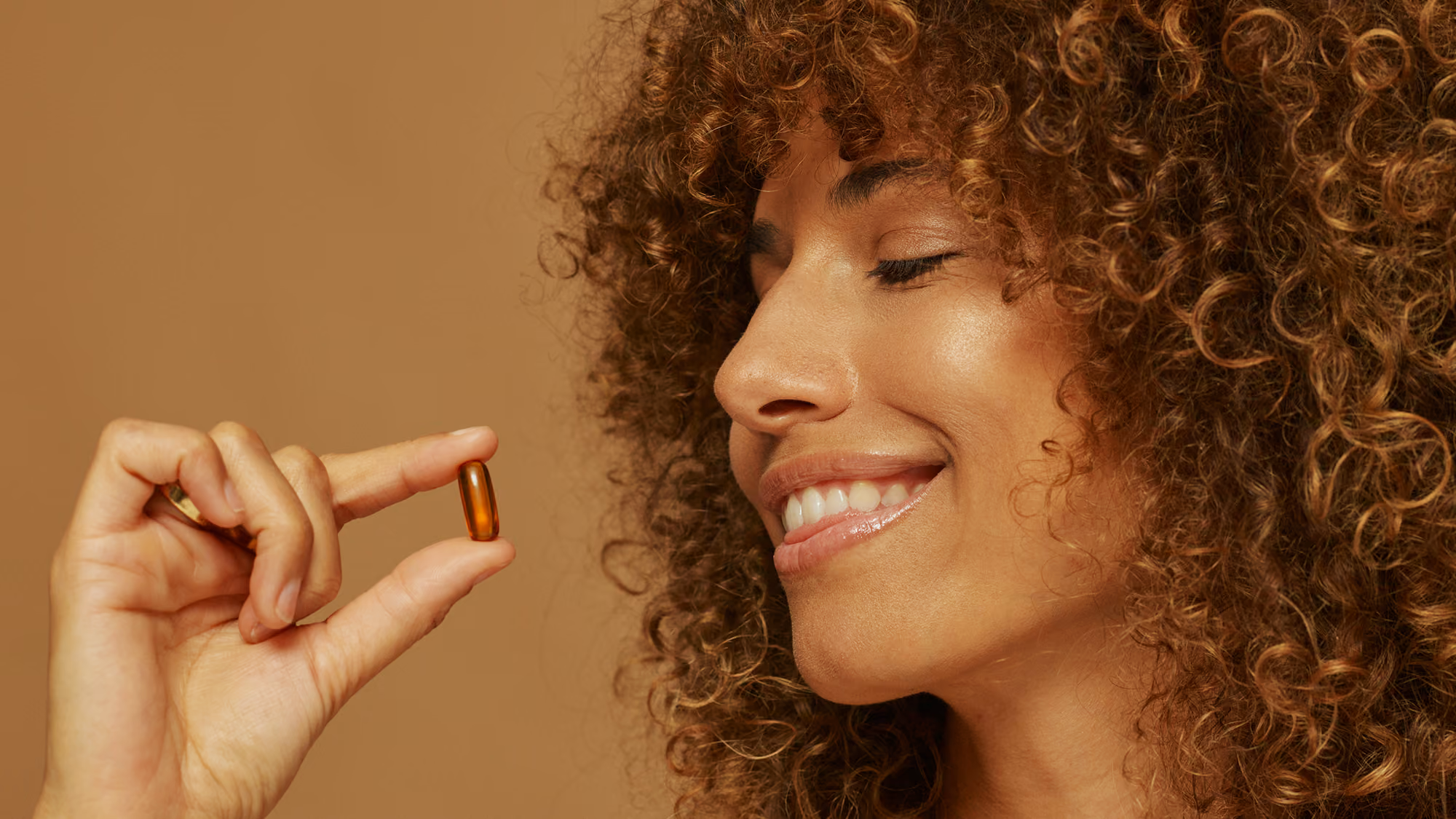 Woman holding a pill.