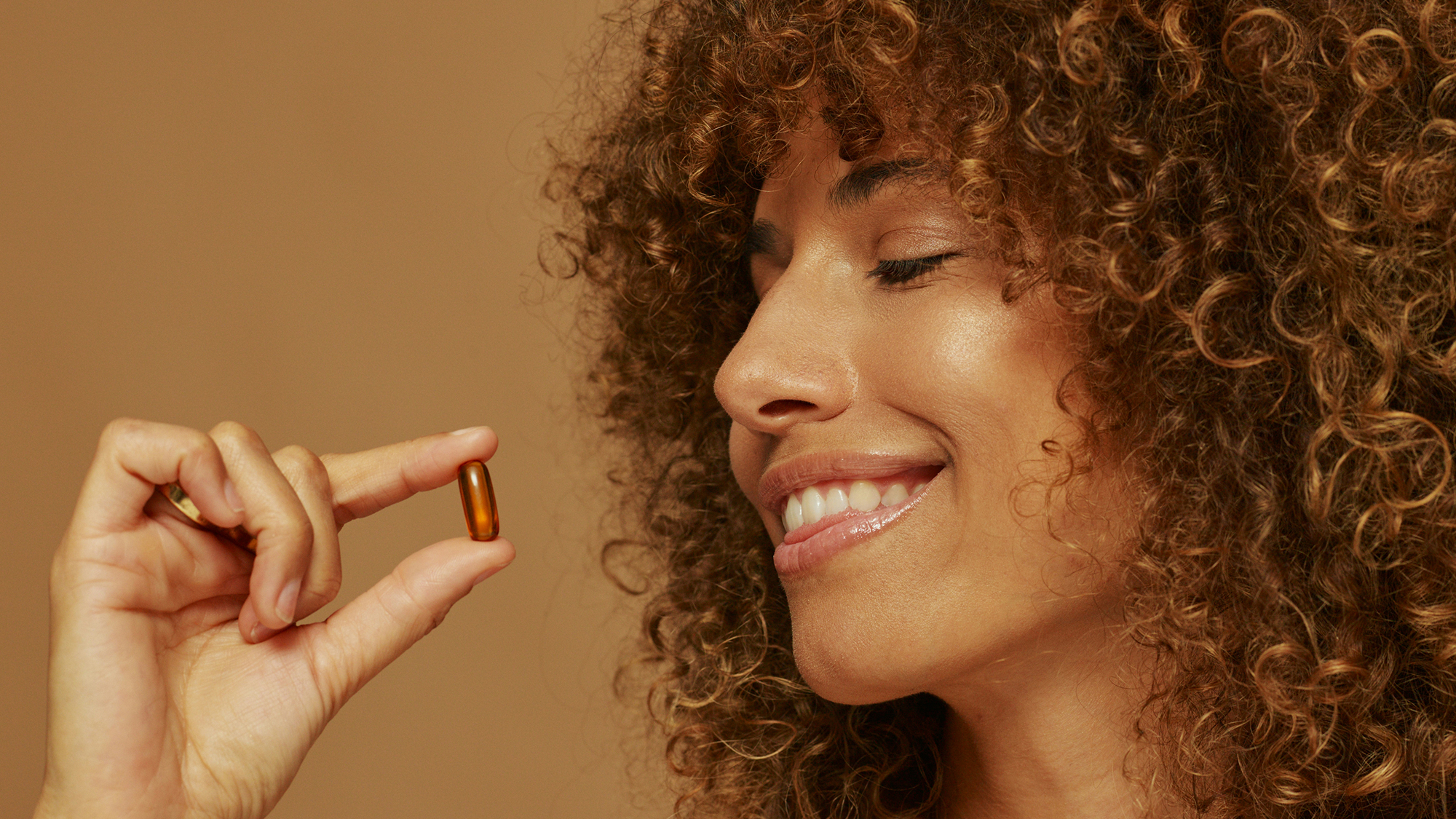 Woman holding a pill.