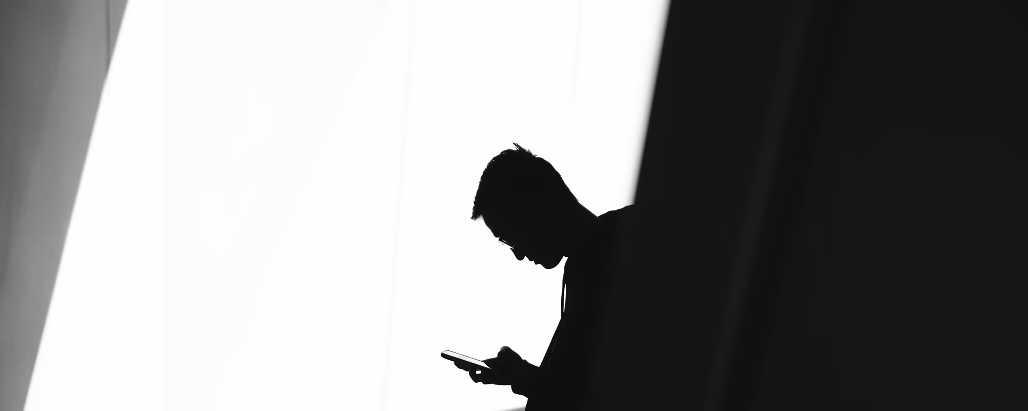 Black and white photo of a man holding a phone.