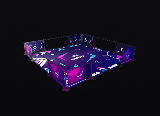 Indoor esports arena setup with illuminated barriers and vibrant geometric patterns on the floor and walls.