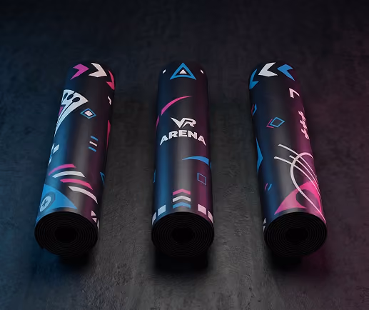 Three rolled-up VR Arena branded mats with colorful geometric patterns on a dark textured surface.