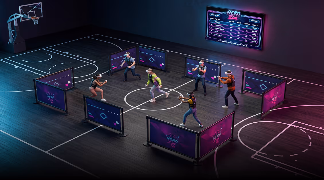 Six people wearing VR headsets and holding controllers are playing a virtual reality game in a basketball court area divided by purple-blue screens displaying 'HERO ZONE'.