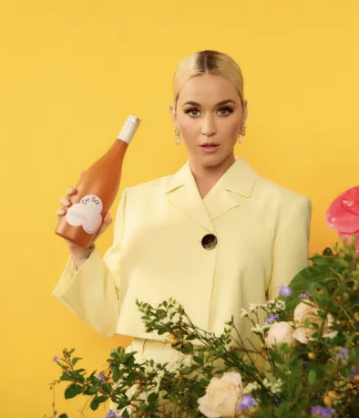 Katy Perry holding a bottle of De Soi by AMASS.