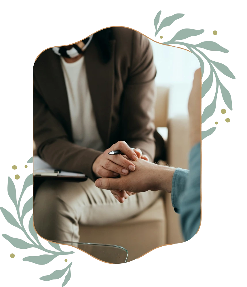 Person in brown jacket holding and comforting another person's hand during a conversation.