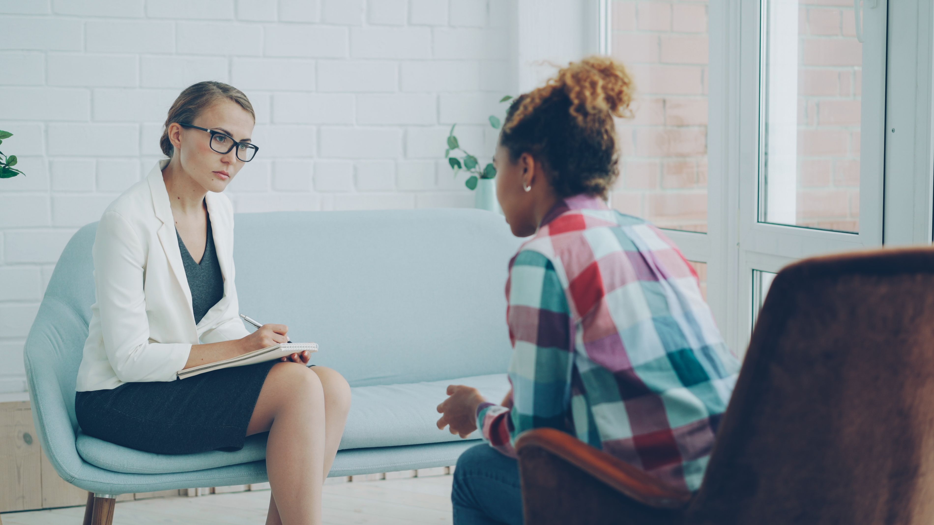 Therapist listening attentively as a client shares their thoughts during an individual therapy session focused on anxiety, emotional wellness, and asking for help.