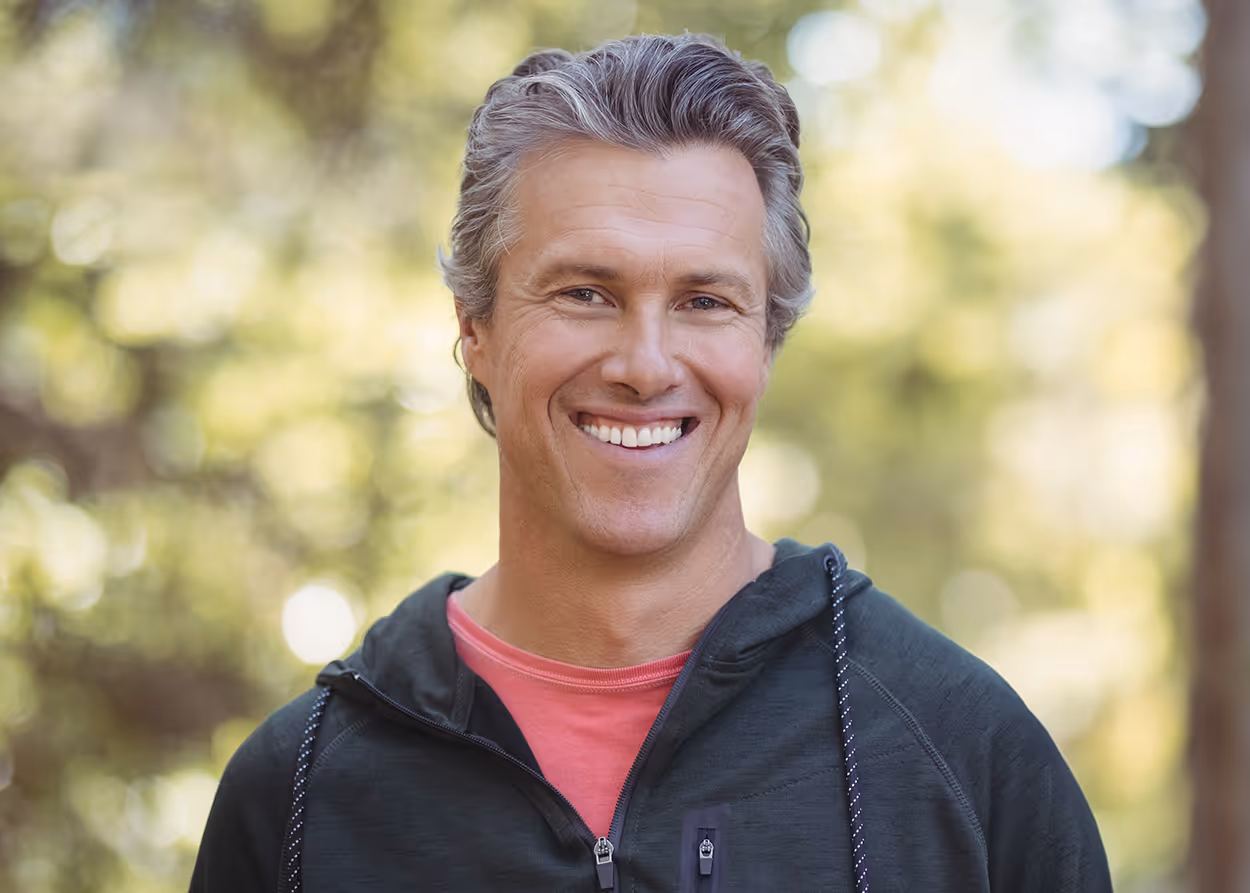 Smiling middle-aged man outdoors for the blog The Quiet Reckoning of Midlife by Willow & Stone Counseling in DFW.