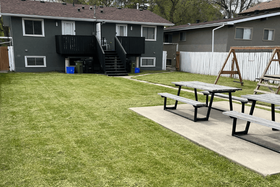 An image of a backyard showcasing a fresh, bright green lawn mowing in Edmonton, AB.