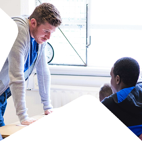 A mentor teaching children in a classroom.