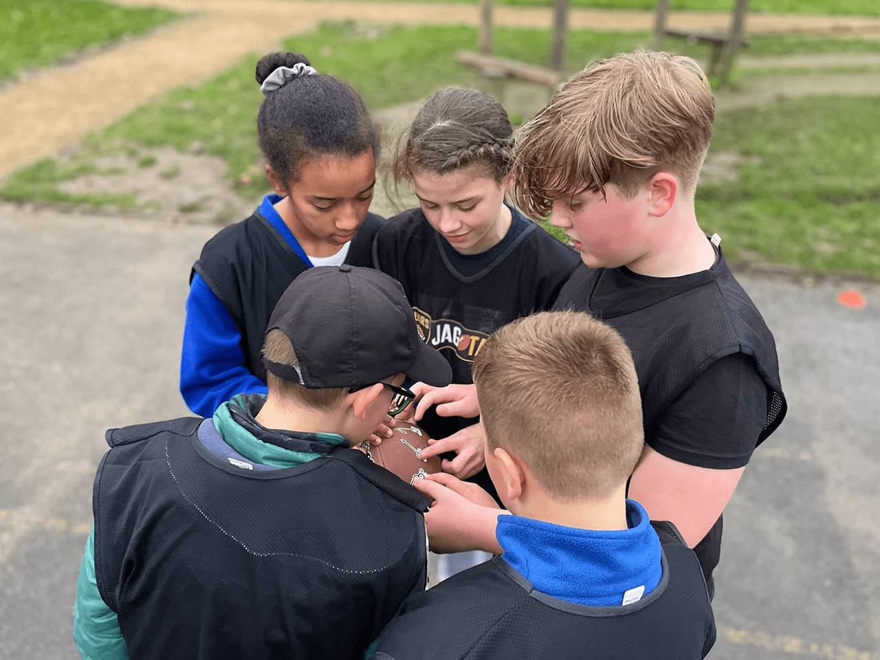 Children in a huddle deciding on a play to carry out in JagTag.