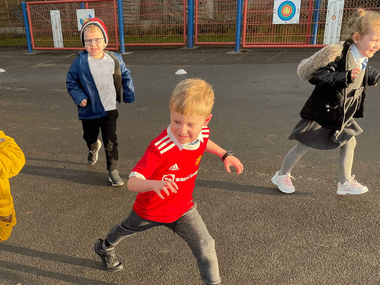 Children playing tag in a school playground.