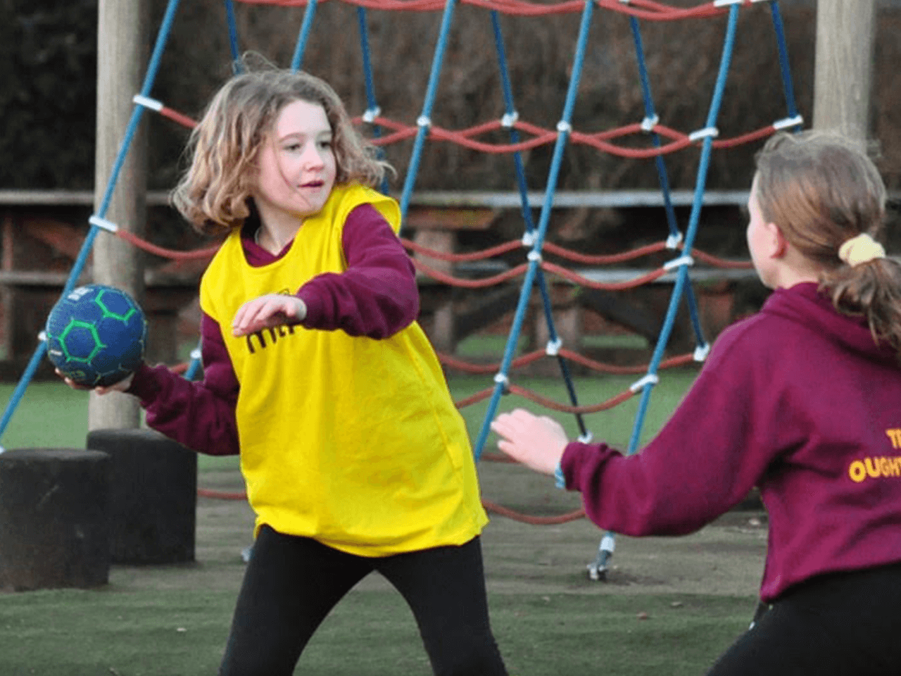 Two girls playing in a handball match.