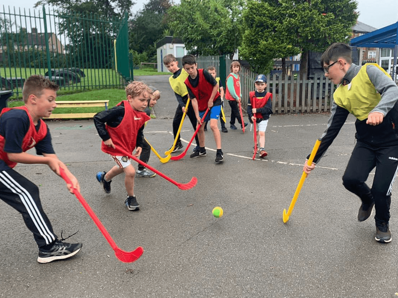 Children playing a hockey match in the playground.