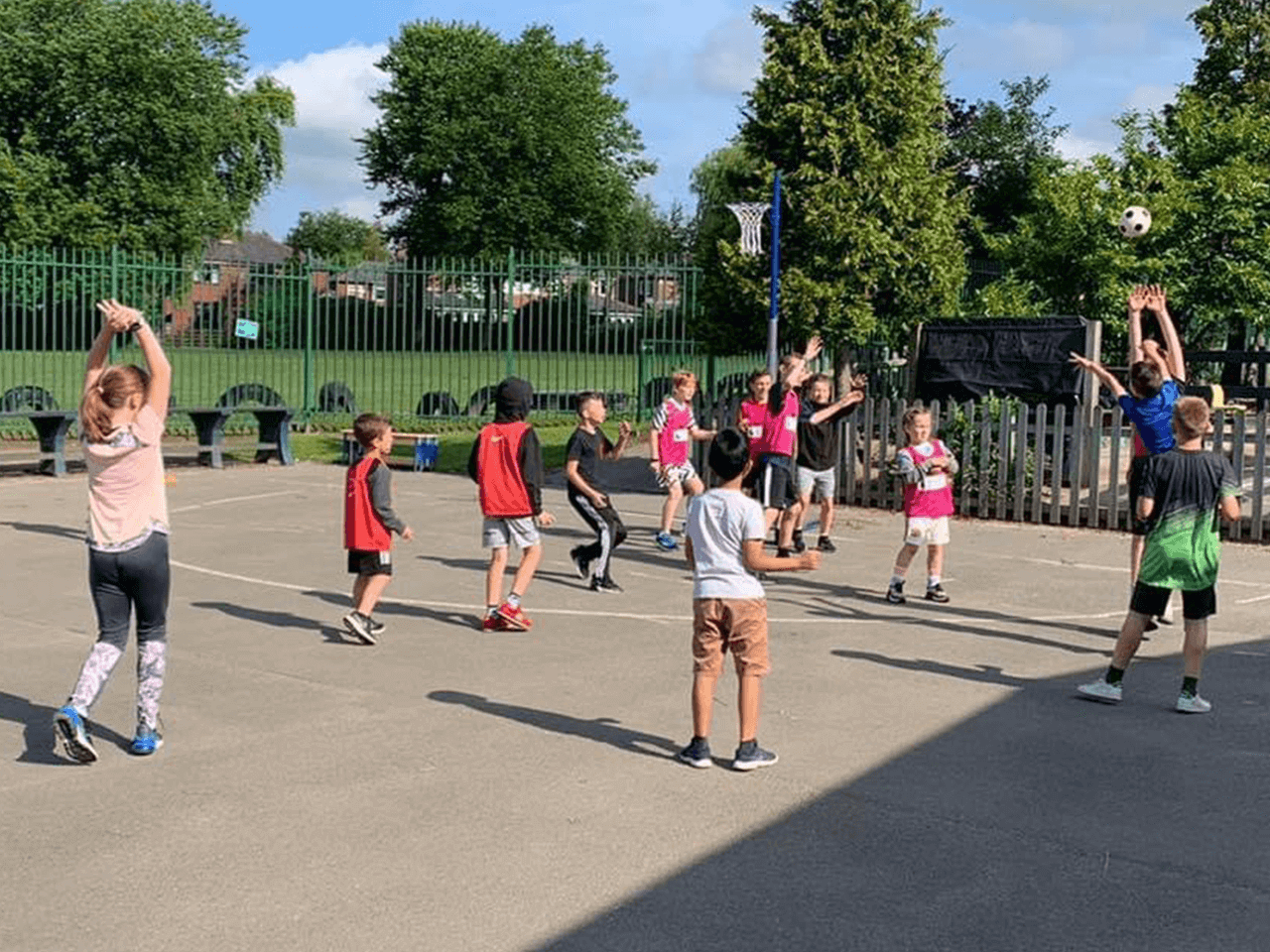 Children playing netball on a school playground.