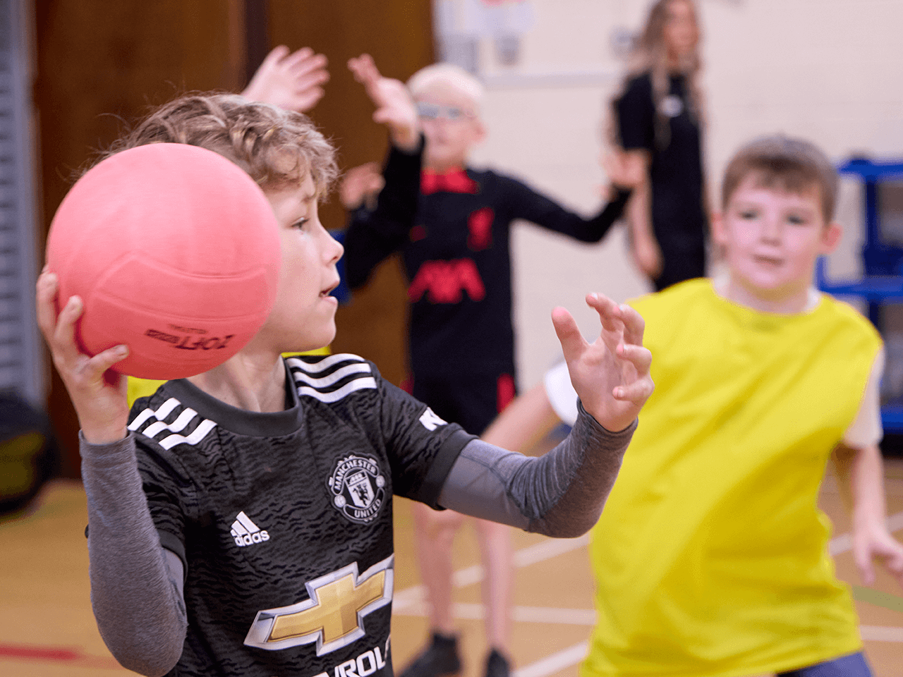 A boy throwing a ball in dodgeball.