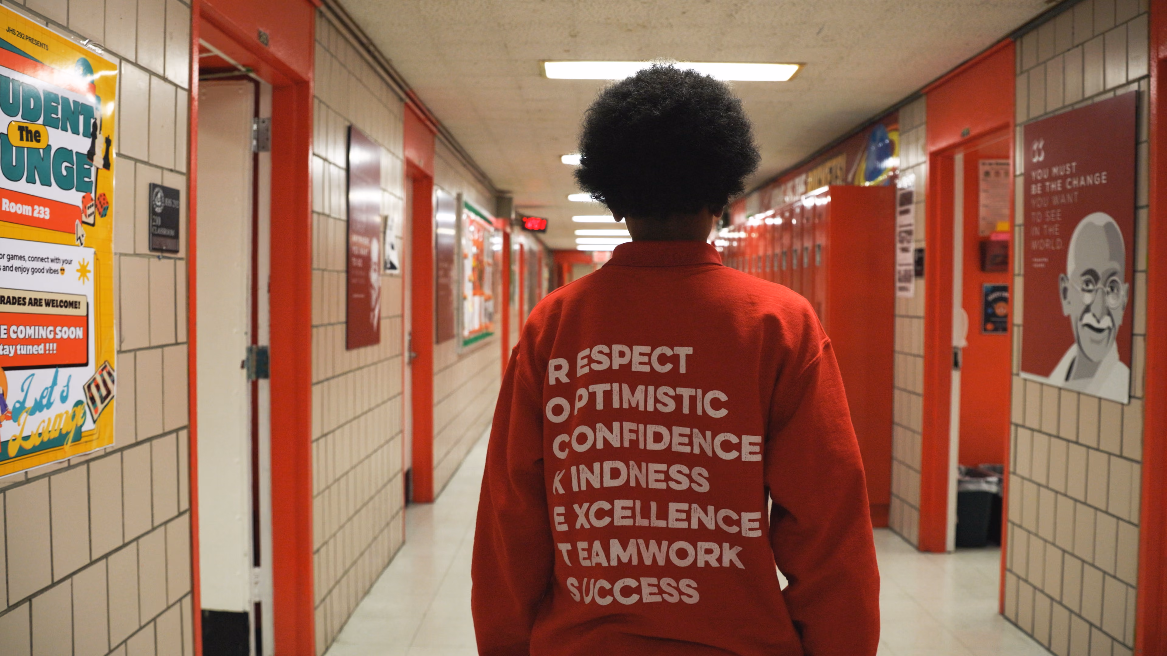 Student walking school hallway wearing ROCKETS values sweatshirt