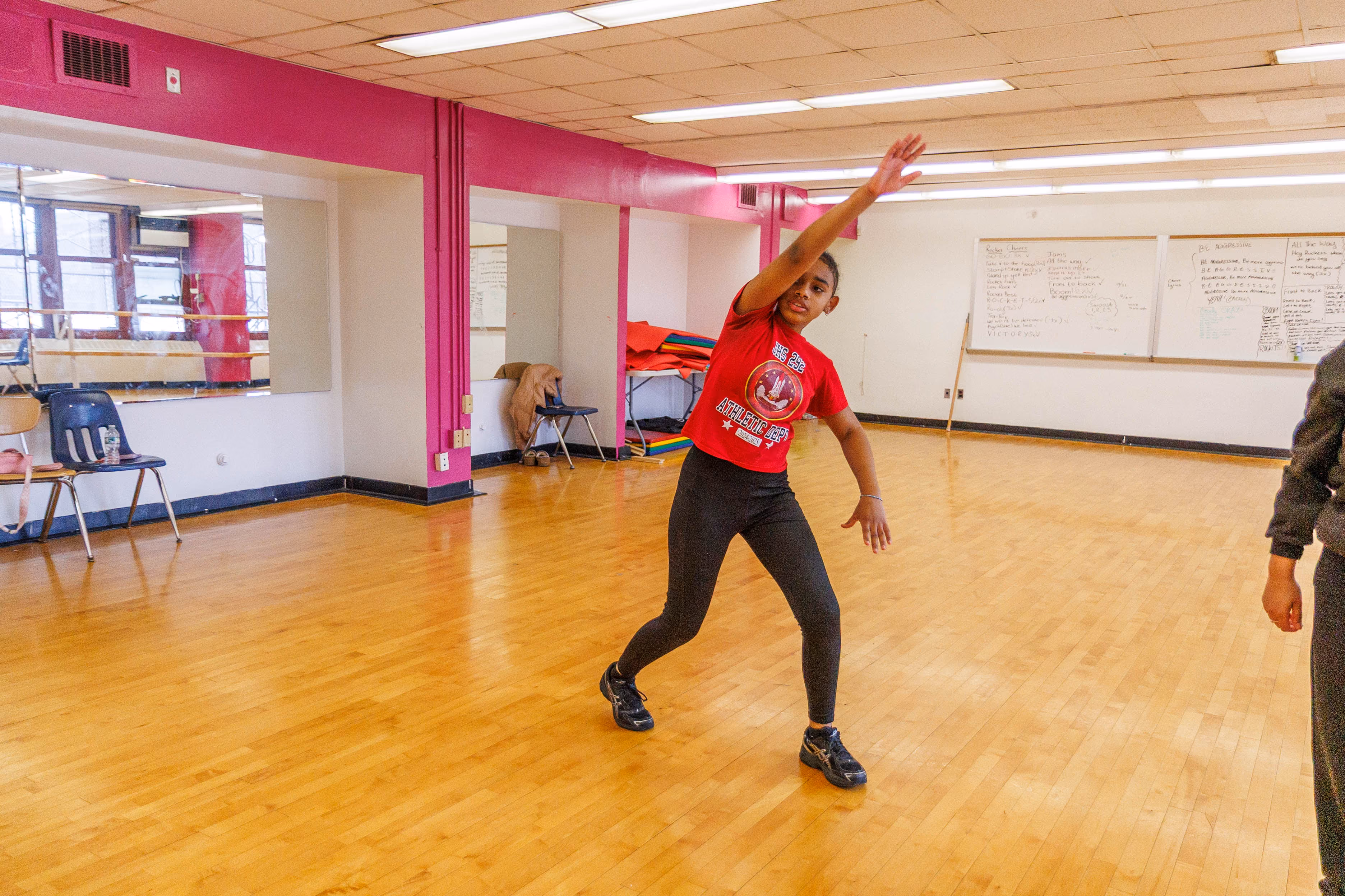 Student dancing in school dance studio with arm raised